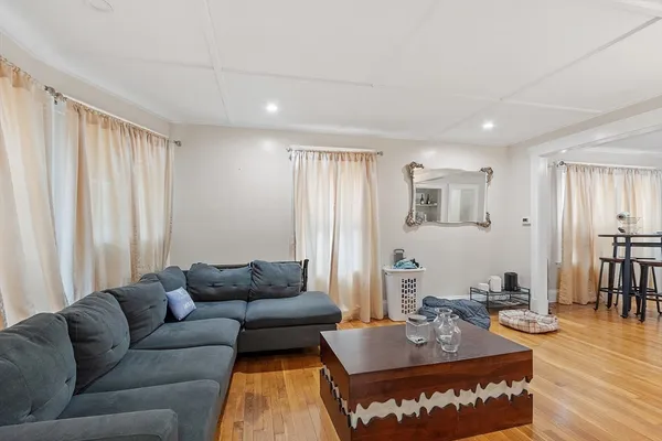 a living room with furniture a wooden floor and a window