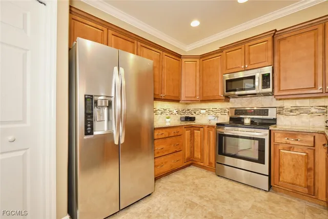 a kitchen with stainless steel appliances granite countertop a refrigerator and a stove top oven