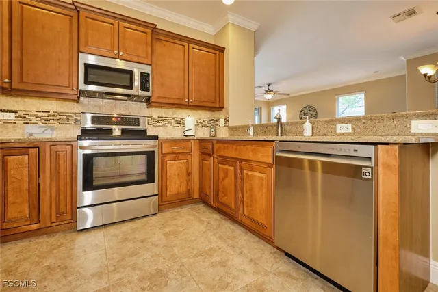 a kitchen with stainless steel appliances granite countertop a stove top oven a sink and dishwasher