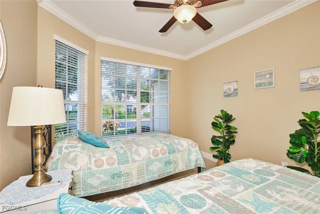 a bedroom with a large bed chandelier and a window