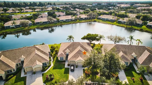 an aerial view of residential houses with outdoor space and lake view