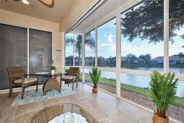 a living room with patio furniture and a floor to ceiling window