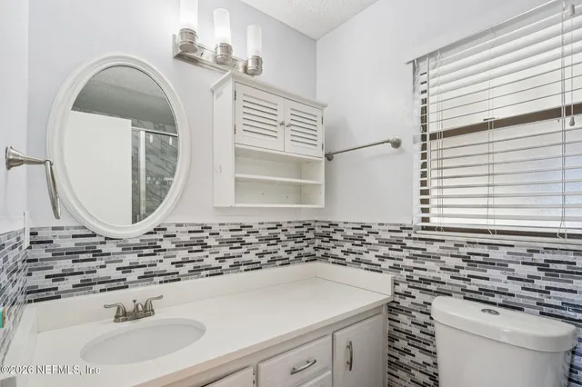 a bathroom with a sink a toilet and a mirror