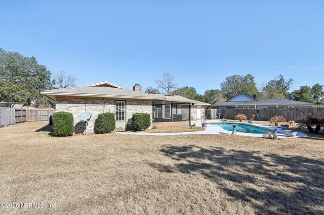 a view of a house with backyard and a tree