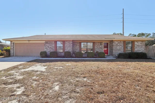 a front view of a house with a yard and palm trees