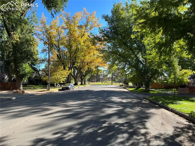 a view of a house with a yard and basketball court