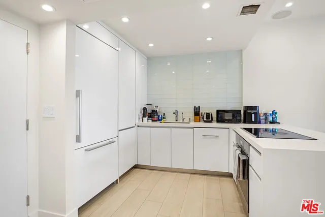 a kitchen with white cabinets and white appliances