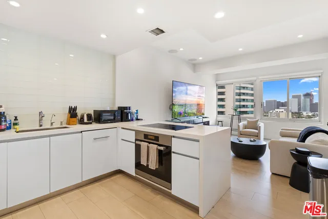 a kitchen with sink a stove and white cabinets
