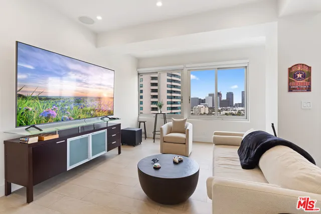 a living room with furniture a flat screen tv and a large window