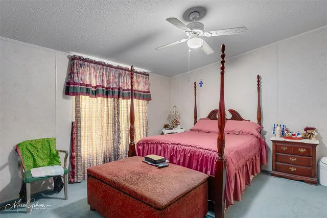 a bedroom with a bed a chandelier and a window