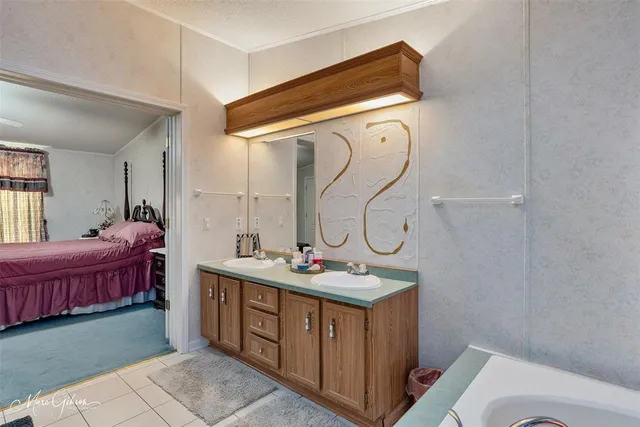 a en suite bathroom with a tub sink and mirror