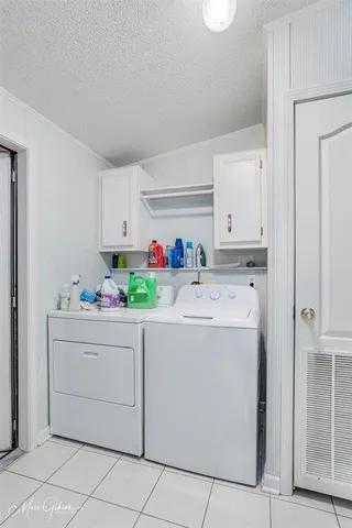 a utility room with cabinets washer and dryer