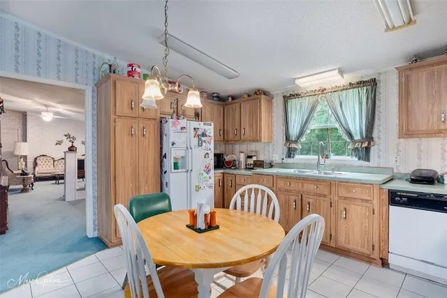 a kitchen with stainless steel appliances granite countertop a kitchen island a table and chairs in it