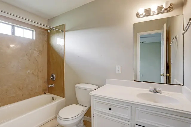 a bathroom with a toilet a sink a mirror a bathtub and shower