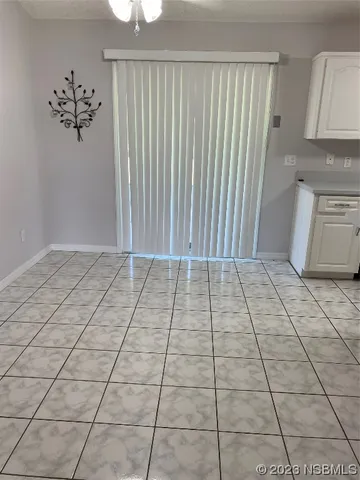an empty room with a ceiling fan and window