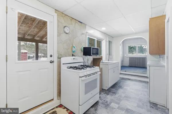 a kitchen with a stove top oven sink and glass door