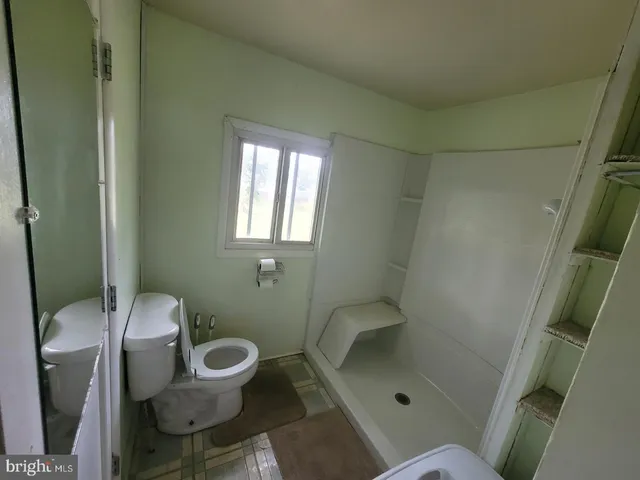a bathroom with a toilet and a shower