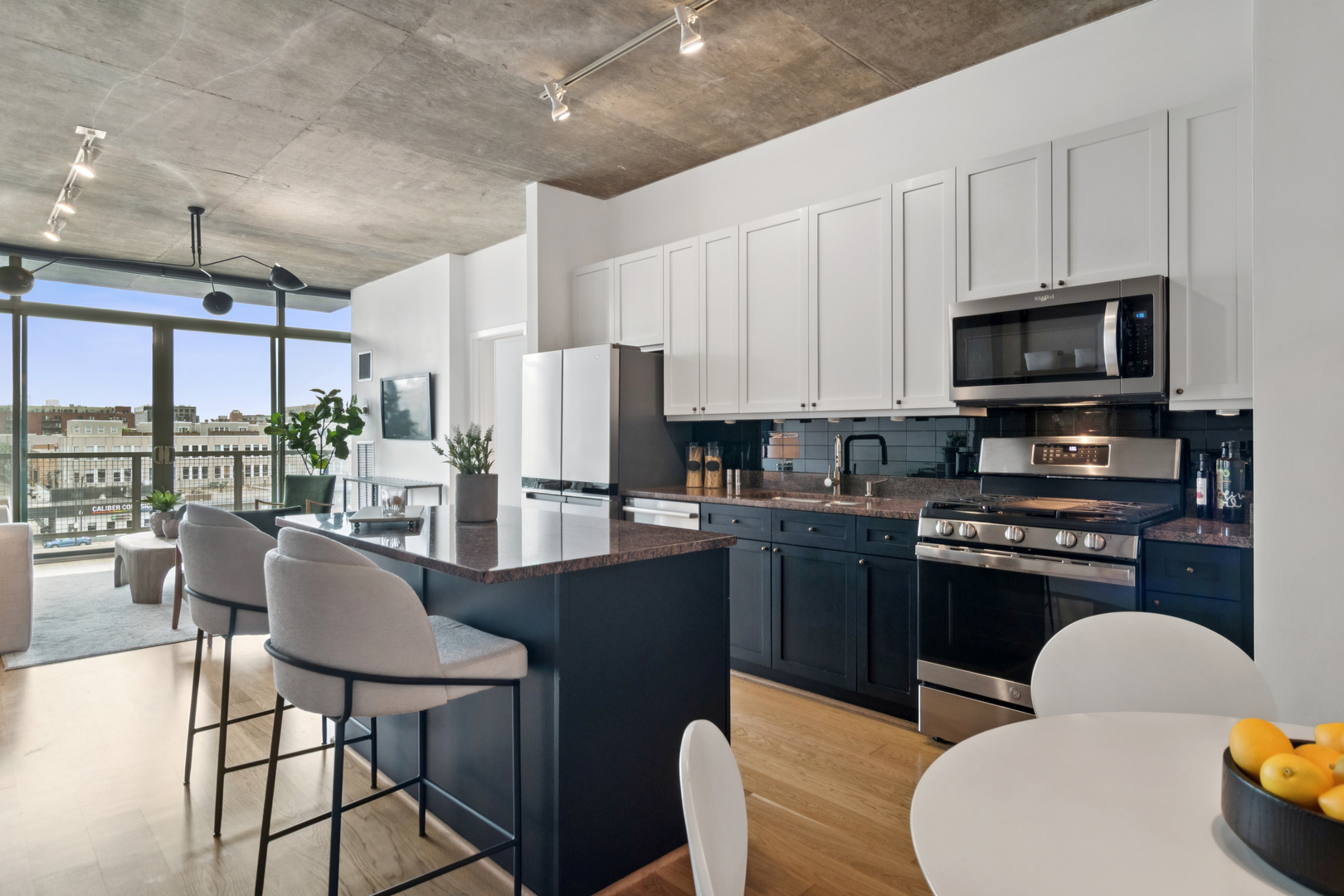321 South Sangamon Street, Unit 501 Chicago, IL 60607 - Photo 4 of 11 a kitchen with stainless steel appliances granite countertop a stove a refrigerator a microwave a dining table and chairs
