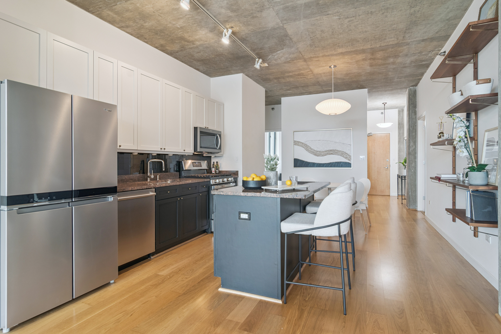 321 South Sangamon Street, Unit 501 Chicago, IL 60607 - Photo 5 of 11 a kitchen with stainless steel appliances a refrigerator a sink dishwasher a stove top oven a dining table and chairs with wooden floor