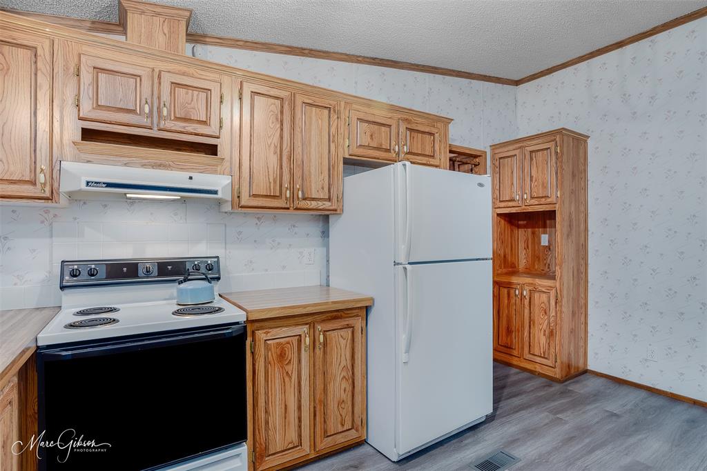 9336 Dean Road Shreveport, LA 71118 - Photo 20 of 25 Kitchen with white appliances, light countertops, crown molding, and light wood-type flooring