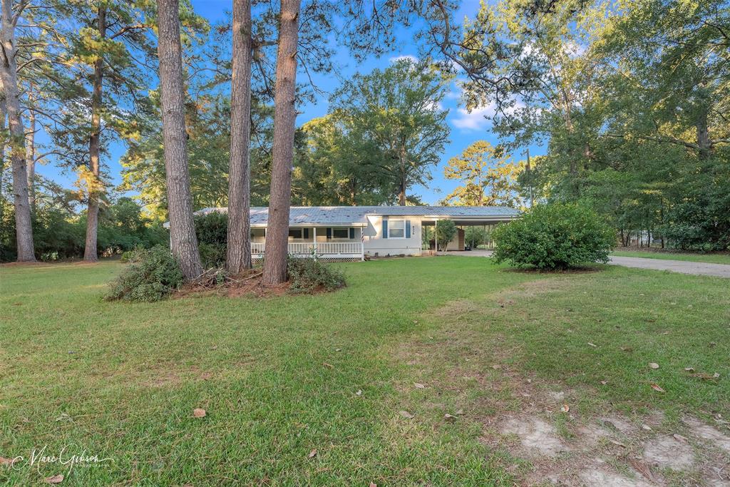9336 Dean Road Shreveport, LA 71118 - Photo 2 of 25 Ranch-style house with a front yard, a carport, a porch, and view of scattered trees
