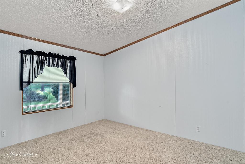 9336 Dean Road Shreveport, LA 71118 - Photo 22 of 25 Carpeted empty room featuring crown molding, a textured ceiling, and a ceiling fan