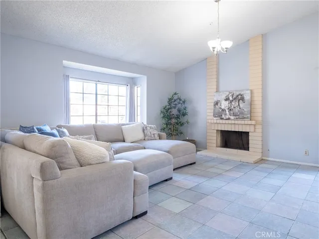 a living room with furniture a fireplace and a chandelier