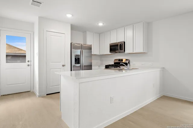 a kitchen with stainless steel appliances a refrigerator sink and microwave