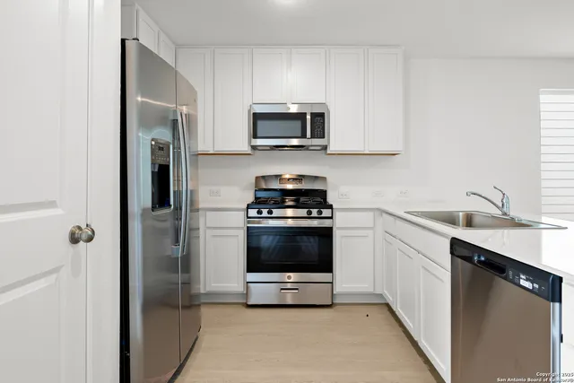 a kitchen with a sink and a stove top oven