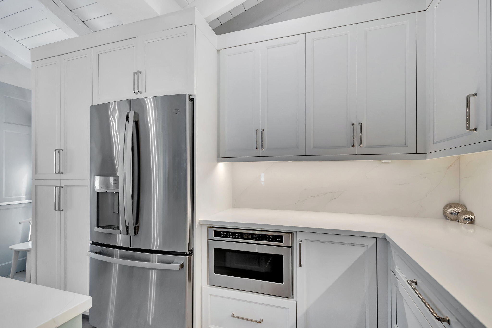 240 Celestial Way, Unit 5 Juno Beach, FL 33408 - Photo 9 of 41 a kitchen with stainless steel appliances white cabinets and a refrigerator