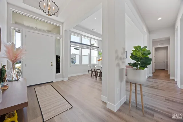 a living room with furniture a rug potted plant and a window