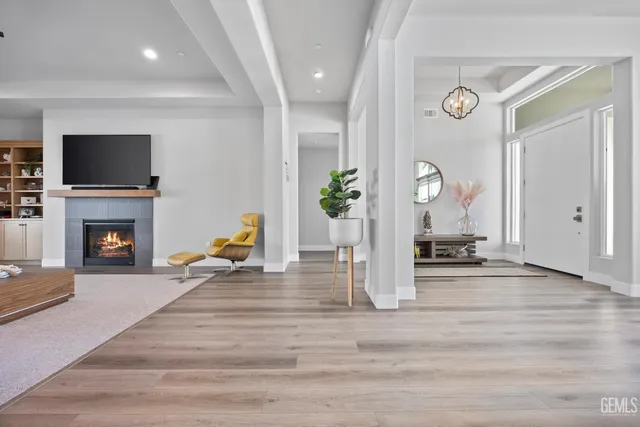 a living room with furniture kitchen view and a chandelier