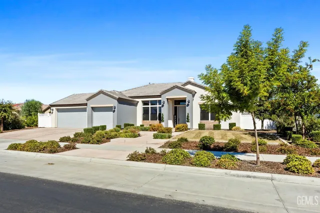 a view of a house with a yard and potted plants
