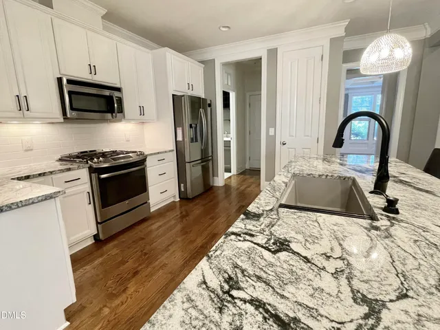 a view of a dining room with furniture wooden floor and a chandelier