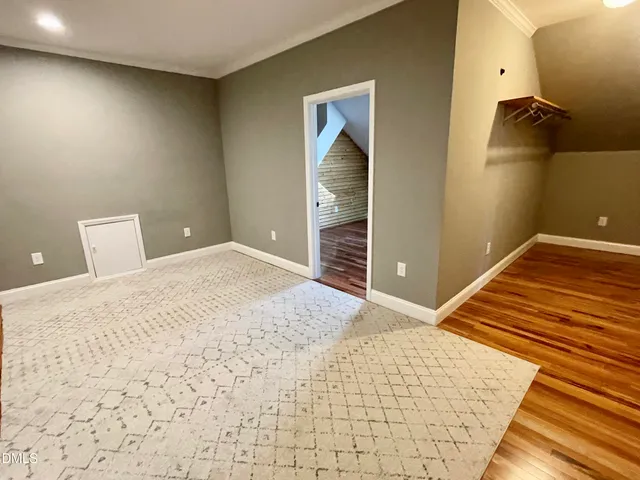 a view of a hallway with wooden floor and a chandelier