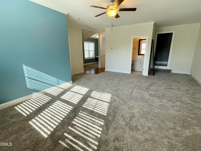 an empty room with wooden floor chandelier and windows
