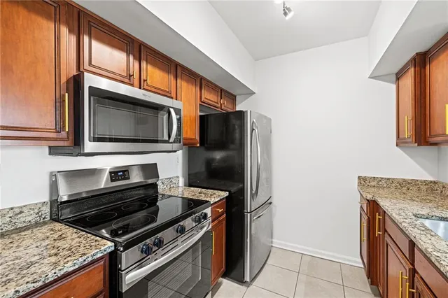 a kitchen with stainless steel appliances granite countertop a sink and a refrigerator
