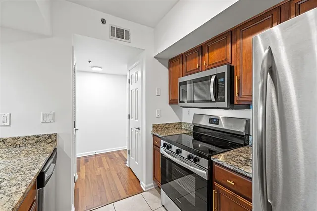 a kitchen with granite countertop a sink stove and refrigerator