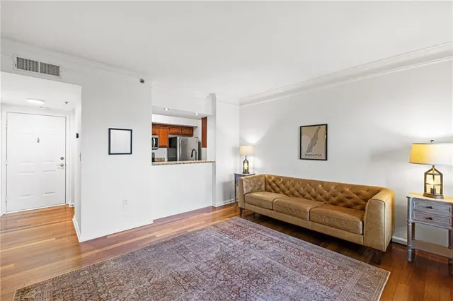 a view of a livingroom with wooden floor and a refrigerator