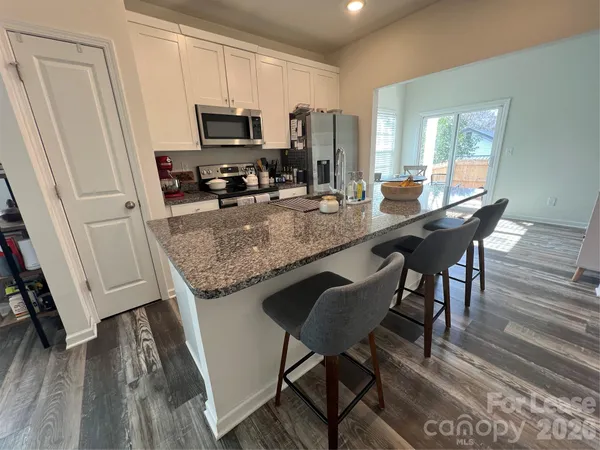 a kitchen with a table chairs and wooden floor