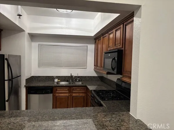 a kitchen with granite countertop a stove and a refrigerator