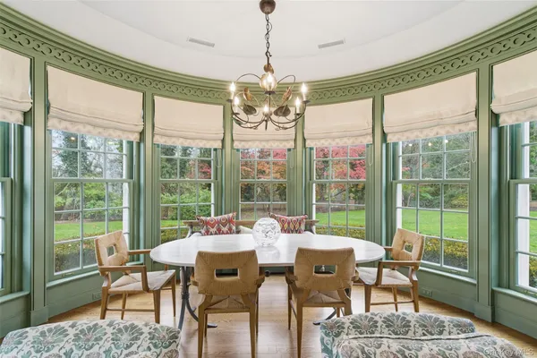 a view of a dining room with furniture large windows and wooden floor