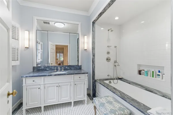 a spacious bathroom with a granite countertop tub sink and mirror
