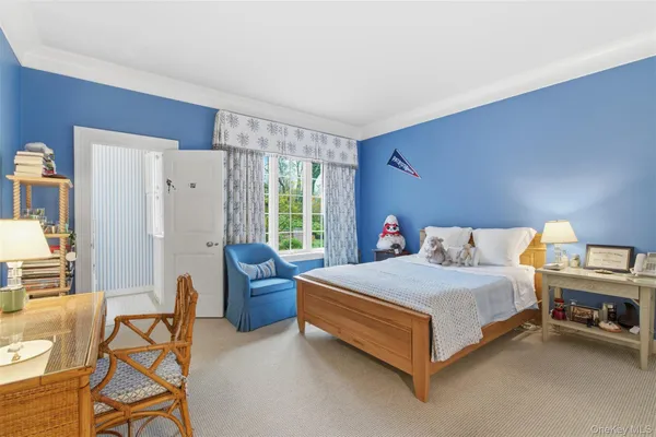 a bedroom with a bed couch and a large window