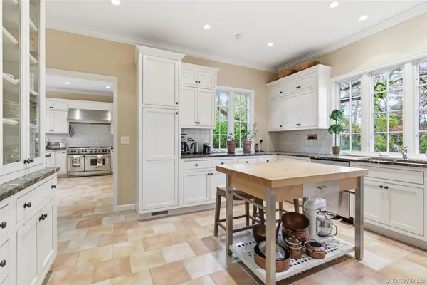 a kitchen with stainless steel appliances kitchen island granite countertop a stove a sink and a refrigerator