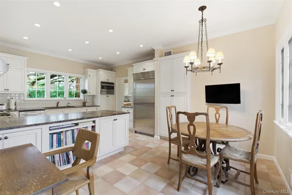 a kitchen with stainless steel appliances kitchen island granite countertop a dining table chairs and sink