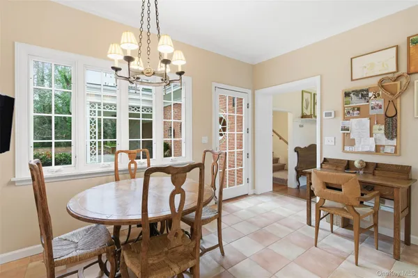 a dining room with furniture a chandelier and wooden floor