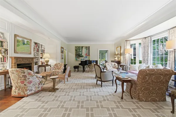 a living room with fireplace furniture and a large window