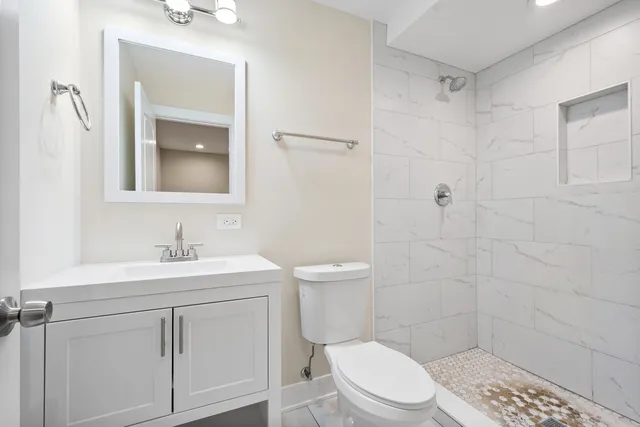 a bathroom with a toilet a sink a shower and vanity