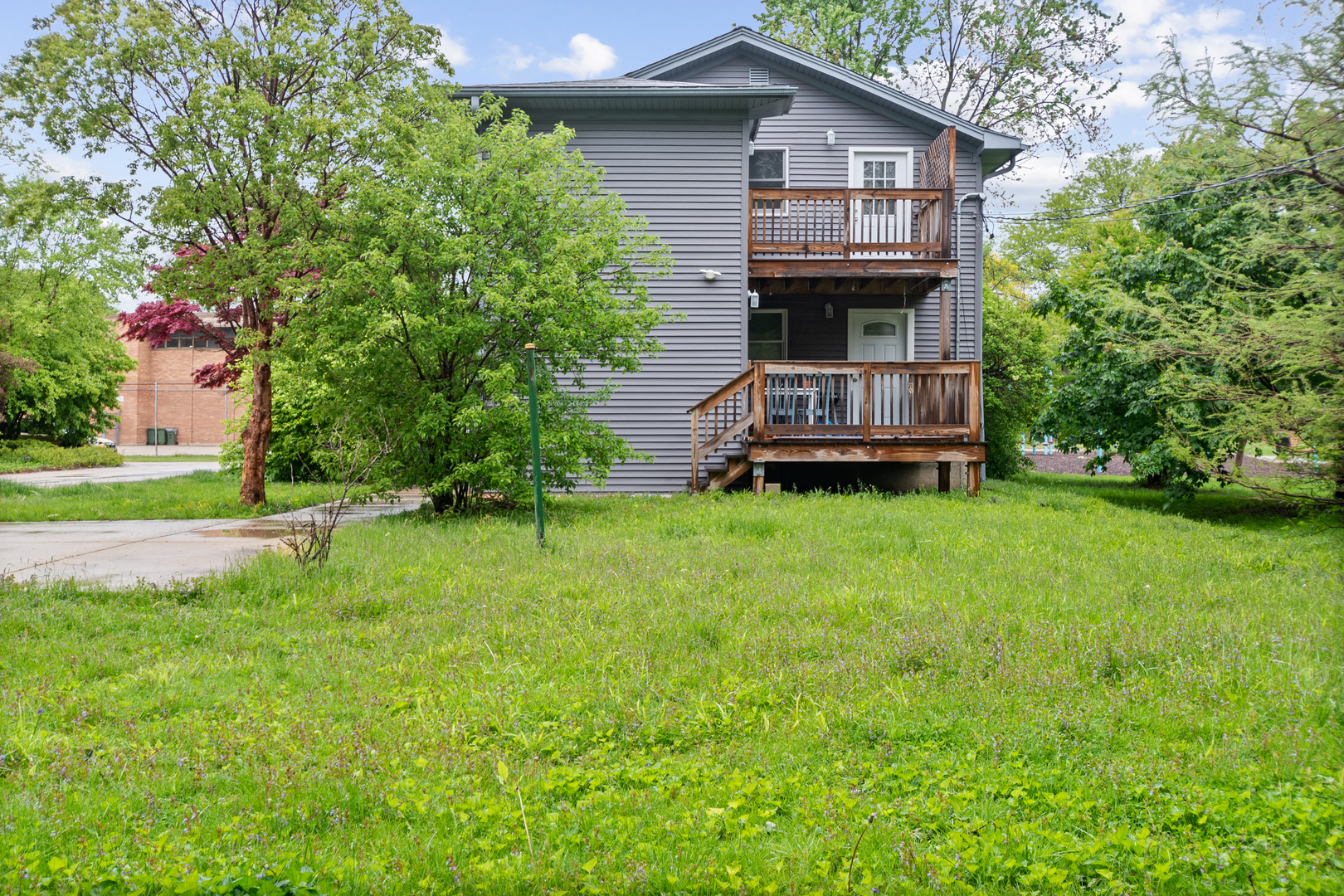 3755 Grove Street, Unit 1 Skokie, IL 60076 - Photo 23 of 24 a view of a house with a small yard plants and large trees